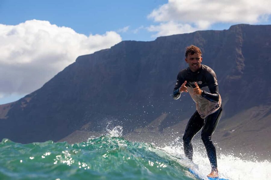 Group surf lessons in Lanzarote, learn with a local team - Getting ready with board, wetsuit, and Lycra