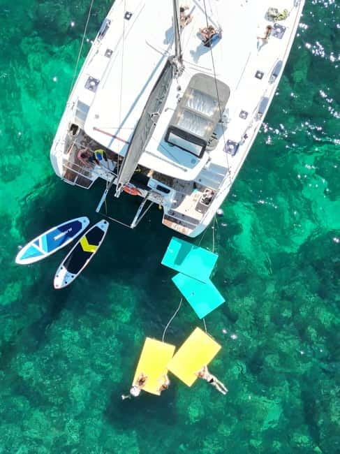 Majorca: Dinner aboard a private catamaran with snorkeling and paddle surfing - Palma’s lights on the ride home
